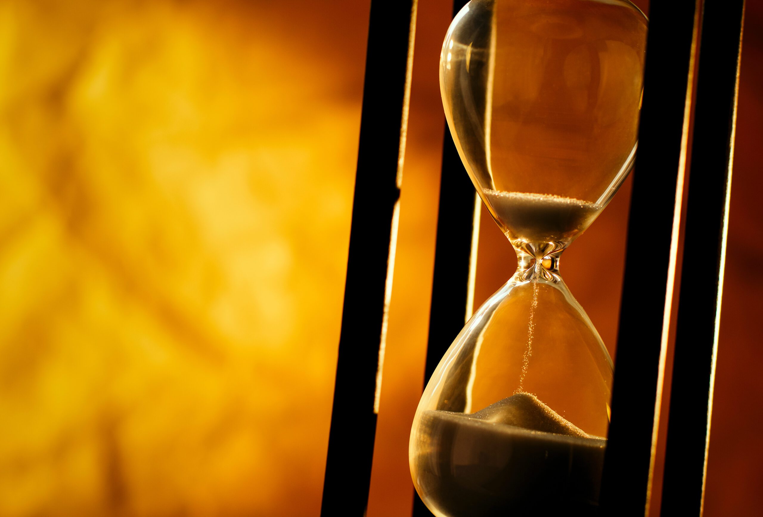 Measuring passing time Conceptual image of measuring passing time with a close up view of sand running through an hourglass or egg timer on a golden background with copyspace